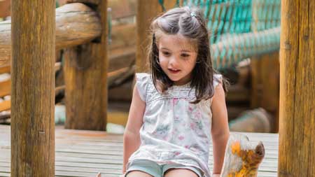 niña jugando en el arenero