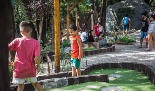 Hijos jugando en el minigolf